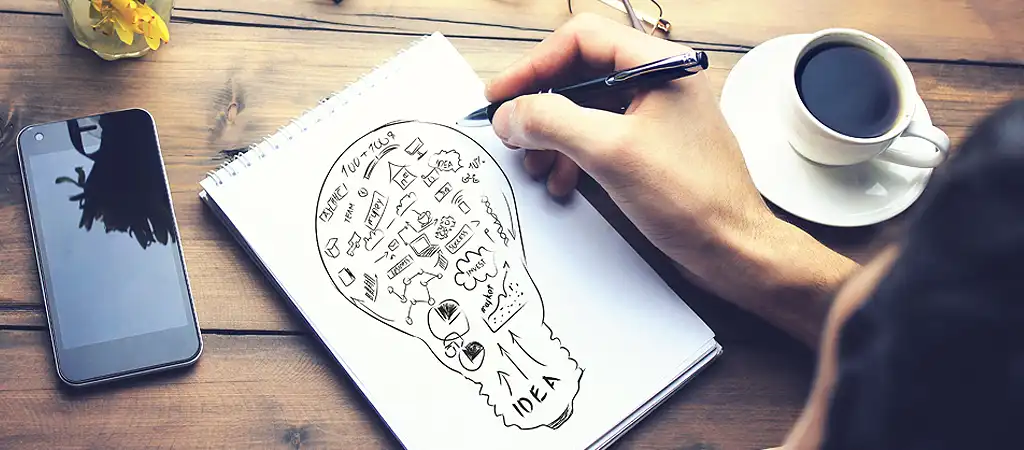 A grafikai tervezés folyamatát jelképező kép, papíron lerajzolva az ötletek és a koncepció.