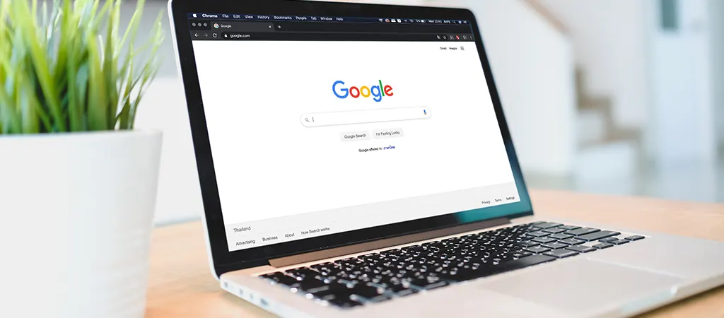 Laptop monitorán a Google keresőoldala látható, utalva arra, hogy a domain név hatással van a Google találati listákra.